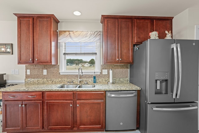 kitchen featuring reddish brown cabinets, stainless steel appliances, tasteful backsplash, and a sink