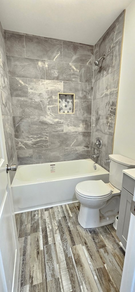 7626 Richmond Rd, Warsaw, VA 22572 - bathroom featuring vanity, toilet, wood finished floors, and shower / bath combination