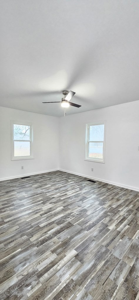 7626 Richmond Rd, Warsaw, VA 22572 - spare room with a ceiling fan, wood finished floors, and a healthy amount of sunlight