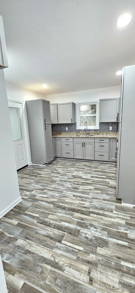 7626 Richmond Rd, Warsaw, VA 22572 - kitchen featuring backsplash, gray cabinets, recessed lighting, wood finished floors, and a sink