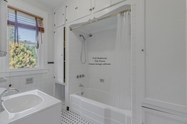 bathroom with vanity, shower / bathtub combination with curtain, and tile walls