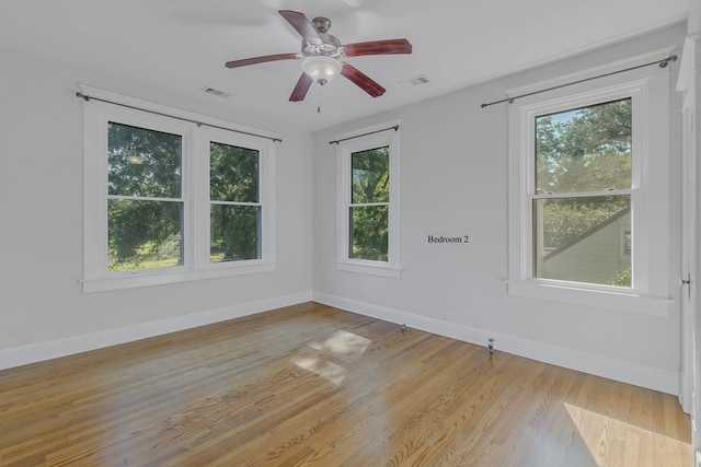 spare room featuring plenty of natural light, ceiling fan, and light wood-type flooring