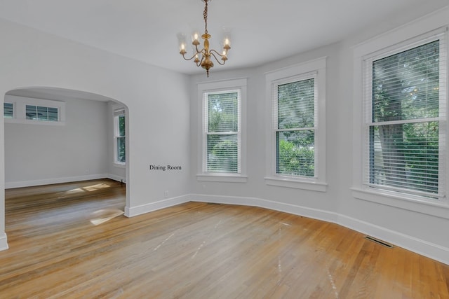 empty room featuring light hardwood / wood-style floors and a chandelier