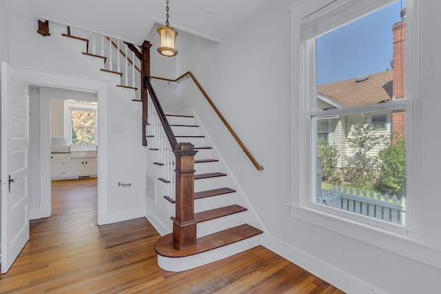 staircase with hardwood / wood-style floors and a healthy amount of sunlight