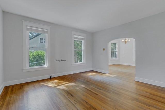 unfurnished room featuring light wood-type flooring and a notable chandelier