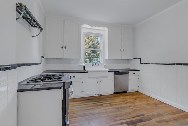 kitchen with white cabinetry, sink, crown molding, hardwood / wood-style floors, and appliances with stainless steel finishes