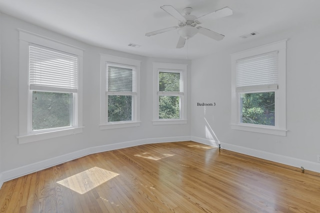 empty room featuring light hardwood / wood-style floors, plenty of natural light, and ceiling fan