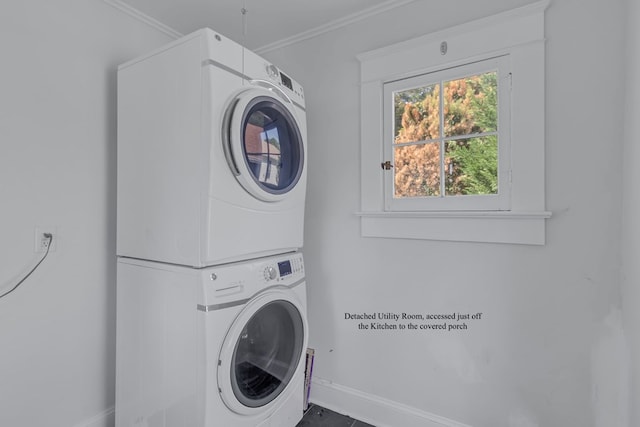 washroom featuring stacked washing maching and dryer and ornamental molding