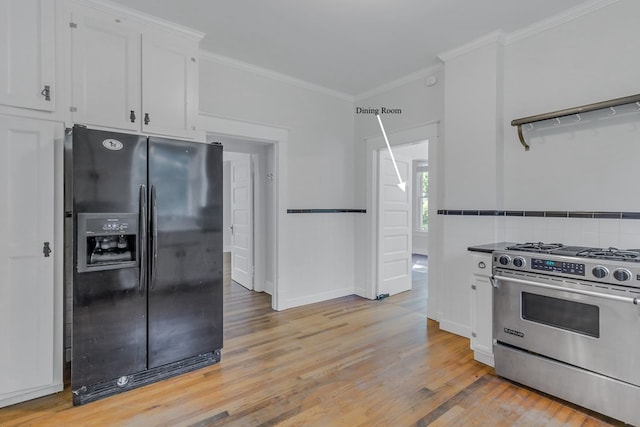 kitchen with light wood-type flooring, black refrigerator with ice dispenser, ornamental molding, stainless steel range, and white cabinets