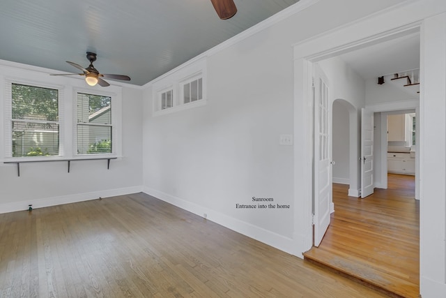 spare room featuring hardwood / wood-style flooring, ceiling fan, and crown molding