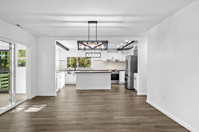 kitchen featuring appliances with stainless steel finishes, backsplash, white cabinetry, and pendant lighting