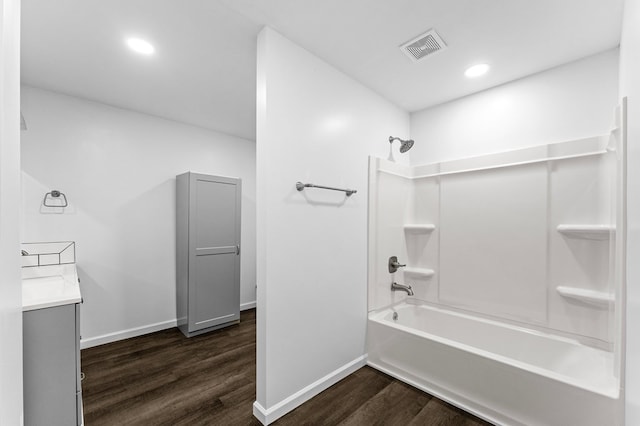 bathroom with hardwood / wood-style floors, vanity, and shower / bath combination