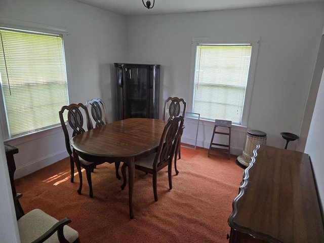 dining room featuring baseboards and carpet flooring