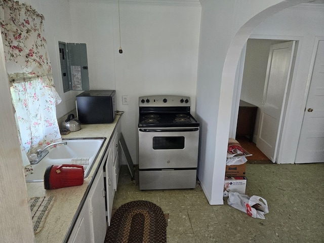 kitchen featuring stainless steel electric stove, light countertops, electric panel, arched walkways, and a sink