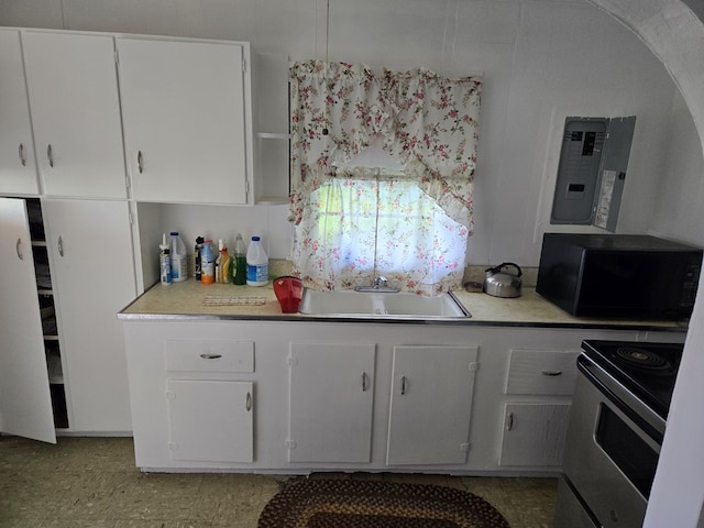 kitchen featuring stainless steel electric stove, white cabinetry, light countertops, and black microwave