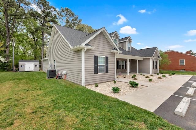 view of front of home featuring central AC, a front lawn, and a shed