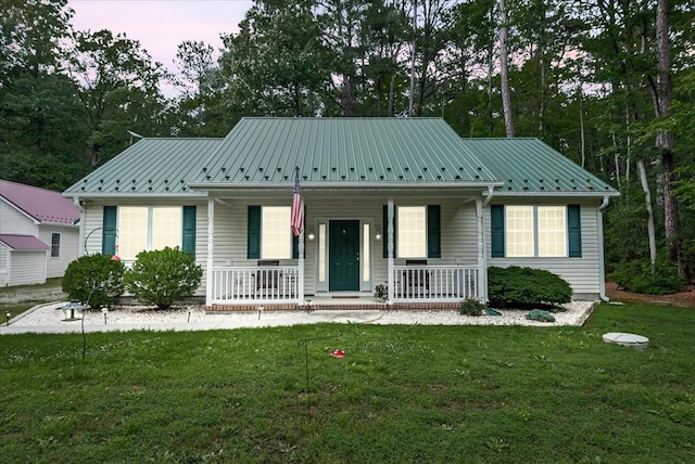 126 Pioneer Trl, Hague, VA 22469 - view of front facade featuring a porch, a front yard, a metal roof, and view of scattered trees