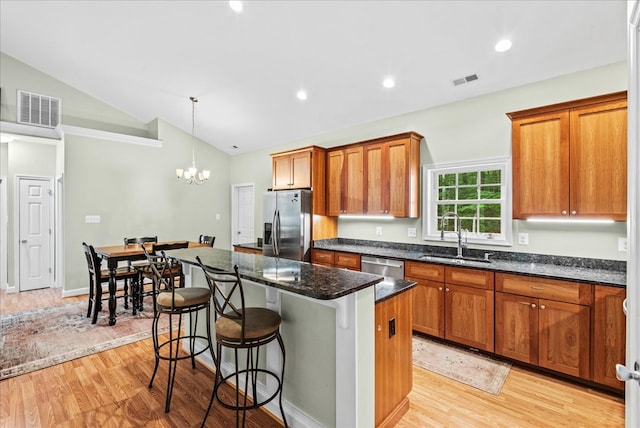 126 Pioneer Trl, Hague, VA 22469 - kitchen with stainless steel appliances, light wood-style floors, a kitchen island, brown cabinetry, and recessed lighting