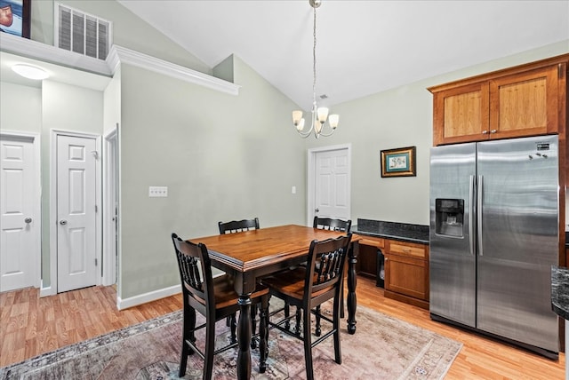 126 Pioneer Trl, Hague, VA 22469 - dining space with high vaulted ceiling, a chandelier, and light wood-style floors