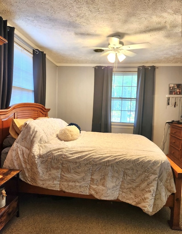 237 Hickory Ln, Reedville, VA 22539 - carpeted bedroom featuring multiple windows, a textured ceiling, and a ceiling fan