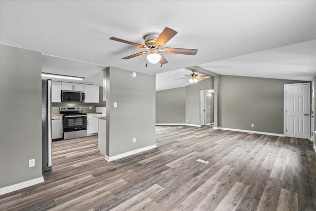 kitchen featuring white cabinetry, vaulted ceiling, stainless steel appliances, and light wood-type flooring