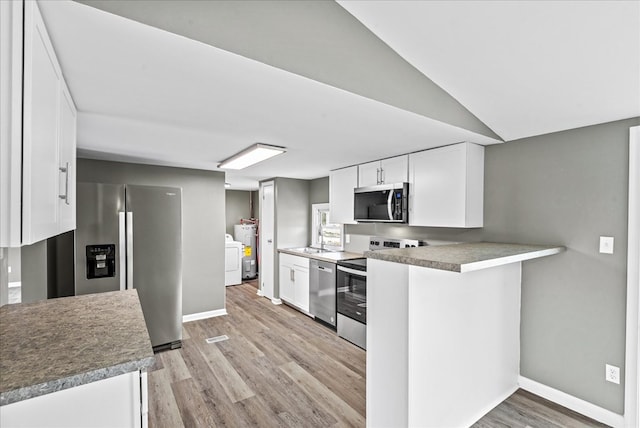 kitchen featuring white cabinetry, stainless steel appliances, independent washer and dryer, kitchen peninsula, and light wood-type flooring