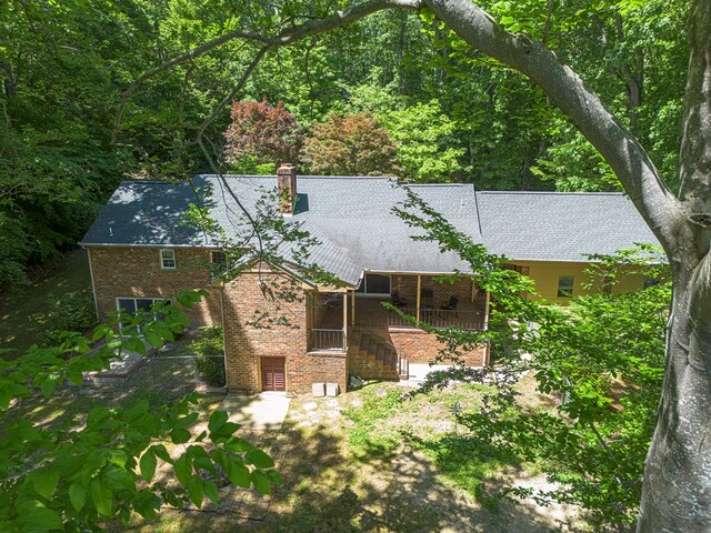 383 Monroe St, Montross, VA 22520 - rear view of house featuring brick siding, a chimney, and a view of trees