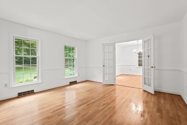 383 Monroe St, Montross, VA 22520 - spare room with french doors, a chandelier, light wood-style flooring, and baseboards