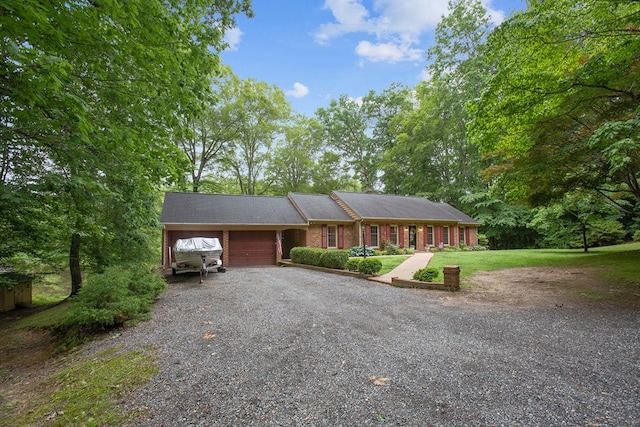 383 Monroe St, Montross, VA 22520 - single story home with a garage, gravel driveway, brick siding, and a front yard