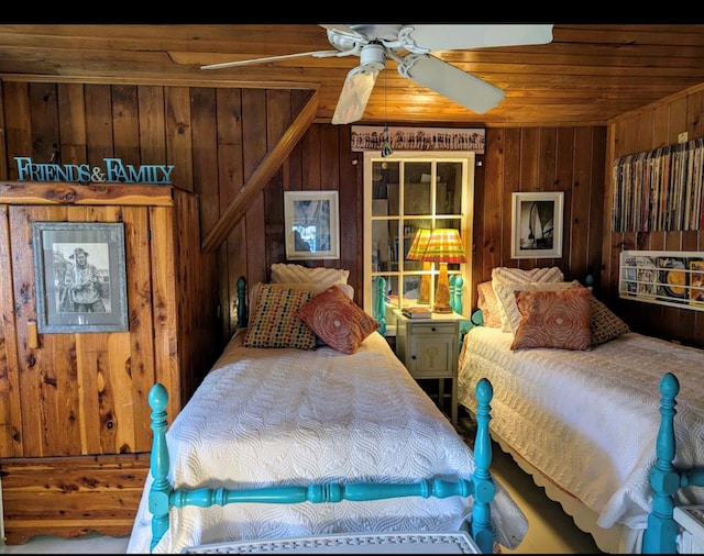 bedroom with ceiling fan and wooden walls