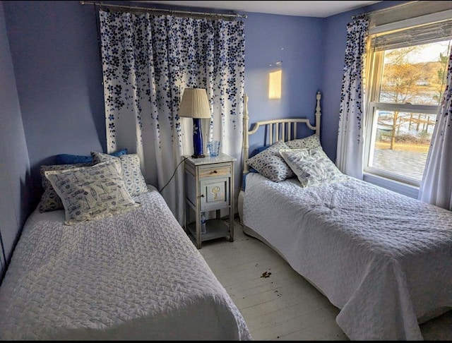 bedroom featuring light wood finished floors and multiple windows