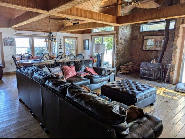 living area featuring wooden ceiling, lofted ceiling with beams, a wood stove, and wood finished floors