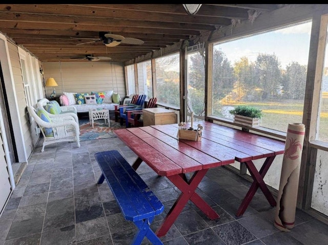 sunroom / solarium featuring a ceiling fan