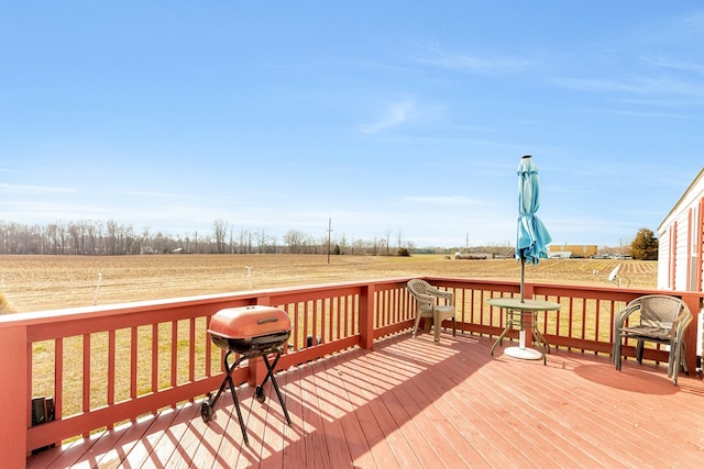 wooden deck with a rural view, a lawn, and area for grilling