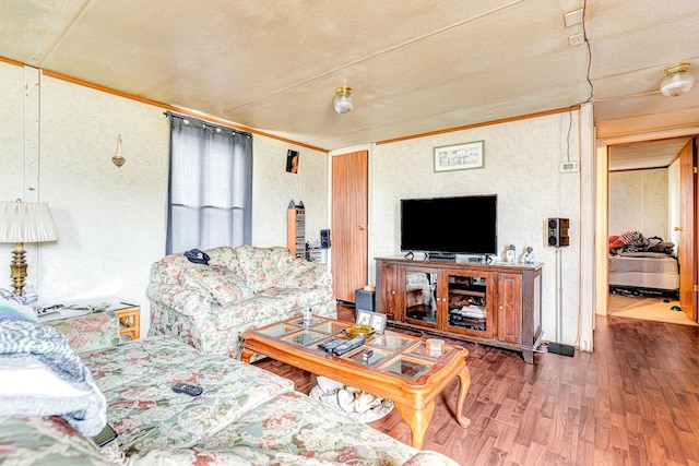 living room with crown molding and wood finished floors