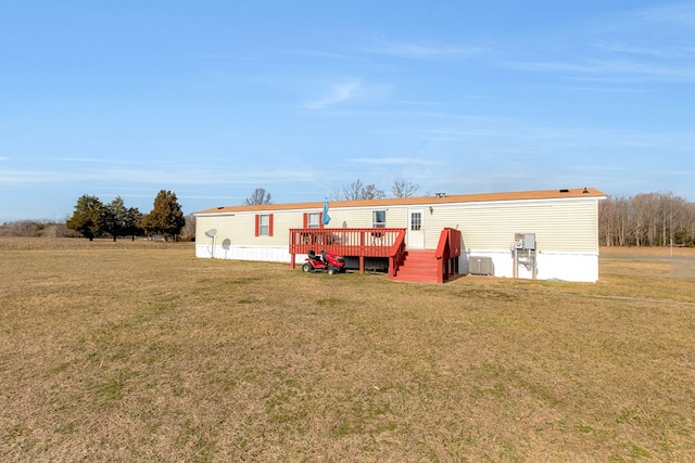 back of property featuring a deck, a yard, and central AC