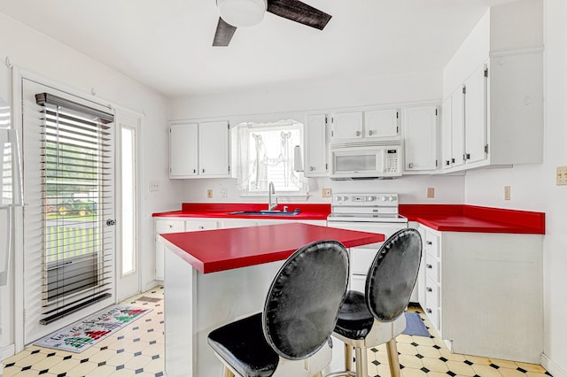 725 Cralle Ave, Tappahannock, VA 22560 - kitchen featuring white microwave, light floors, a ceiling fan, and white cabinets