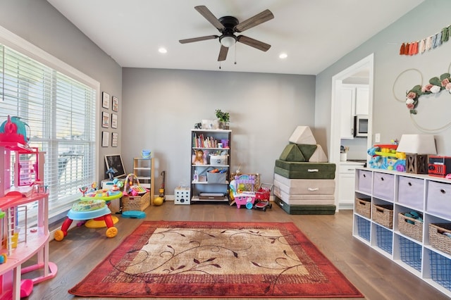 rec room with ceiling fan and dark wood-type flooring