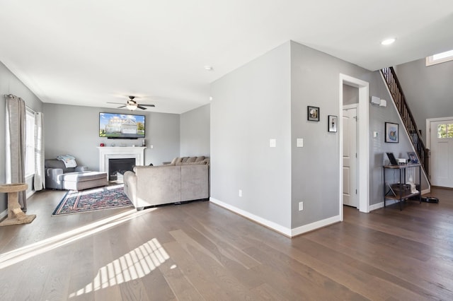 living room featuring ceiling fan and dark wood-type flooring