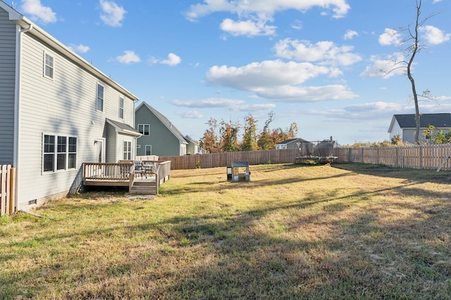 view of yard with a wooden deck and a trampoline