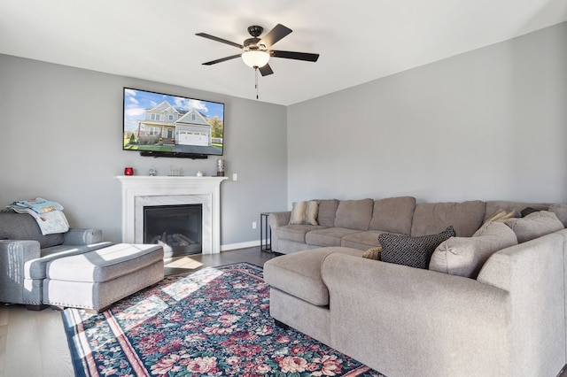 living room with ceiling fan, a fireplace, and hardwood / wood-style flooring