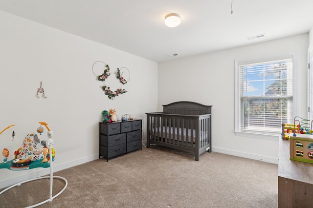 carpeted bedroom featuring a nursery area