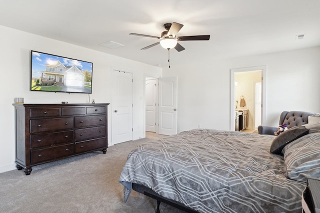 bedroom featuring light carpet, connected bathroom, and ceiling fan