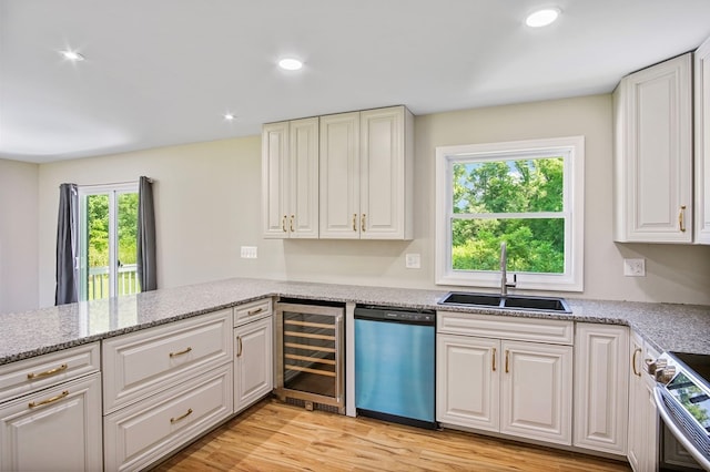 kitchen with sink, beverage cooler, stainless steel appliances, light stone counters, and white cabinets