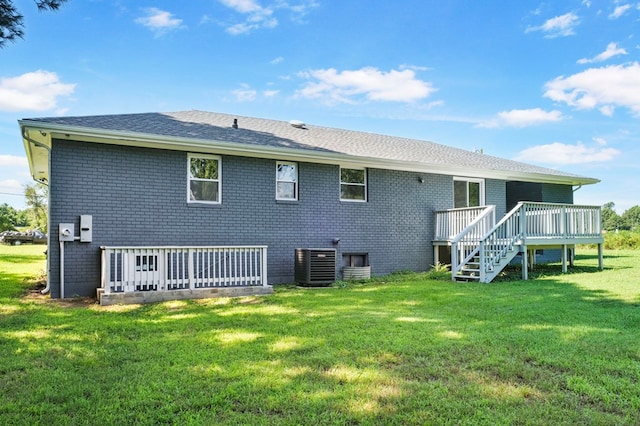 rear view of house featuring a yard, a deck, and central air condition unit