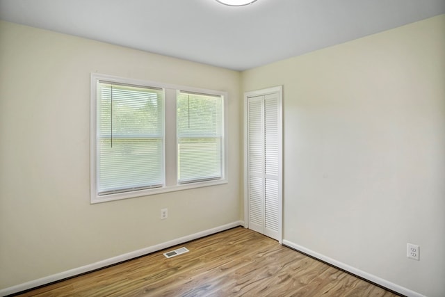 unfurnished bedroom featuring a closet and light wood-type flooring