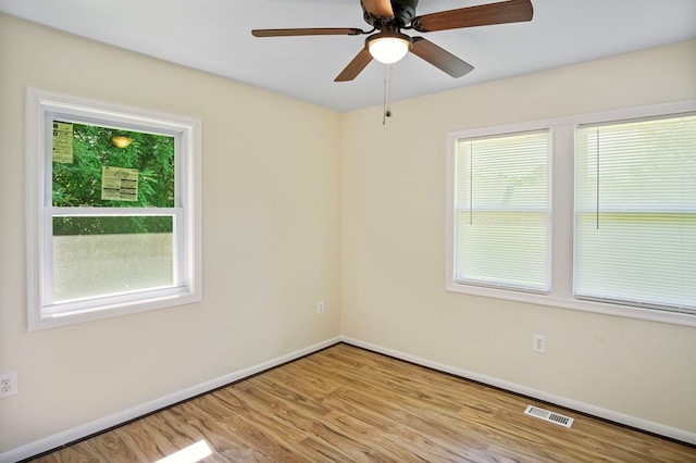 spare room featuring light hardwood / wood-style flooring, a wealth of natural light, and ceiling fan