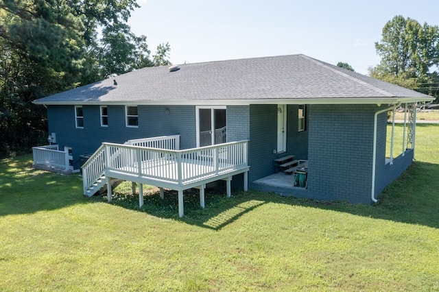 back of property featuring a yard and a wooden deck