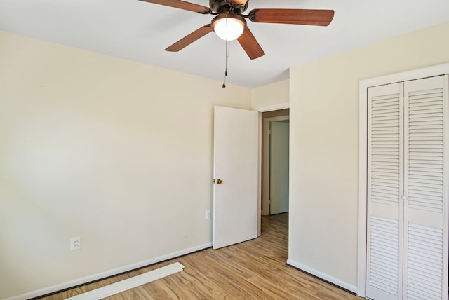 unfurnished bedroom with ceiling fan, a closet, and light wood-type flooring