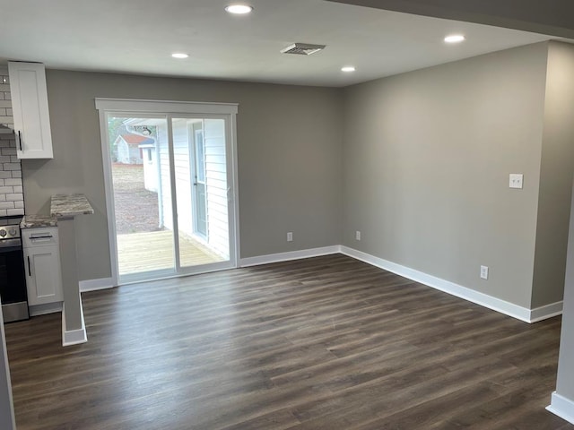 unfurnished living room with dark wood-style flooring and baseboards